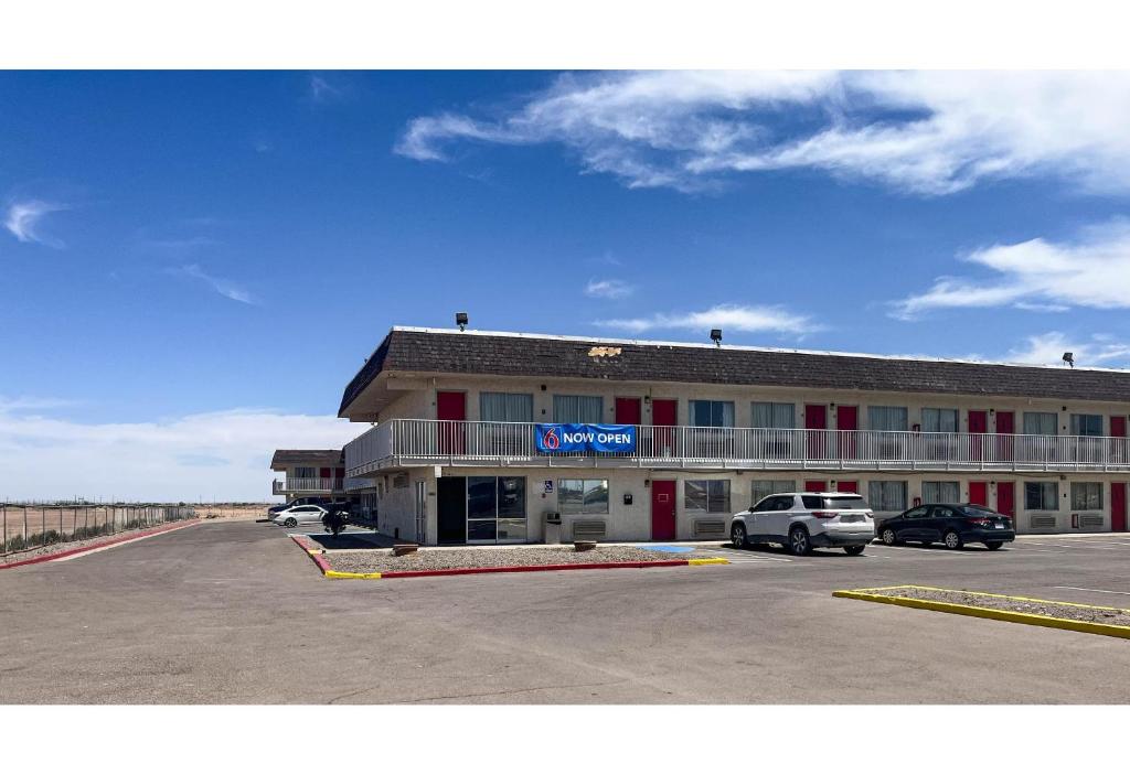 a hotel with a car parked in a parking lot at Studio 6 Pecos Texas in Pecos