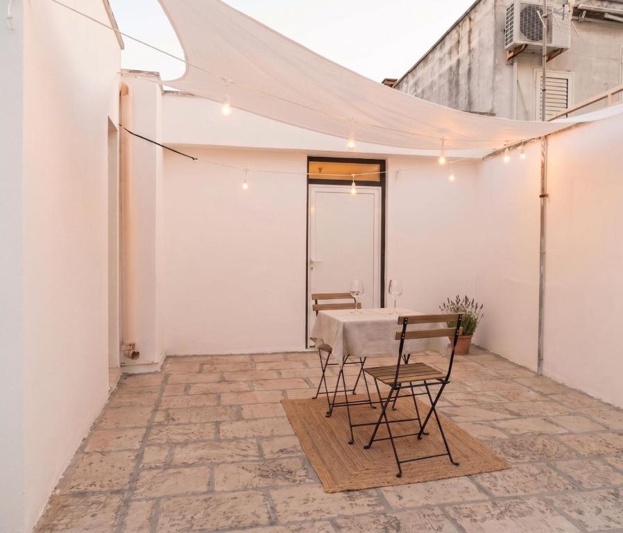 a patio with a table and chairs and a white wall at SteLuRe in Aradeo