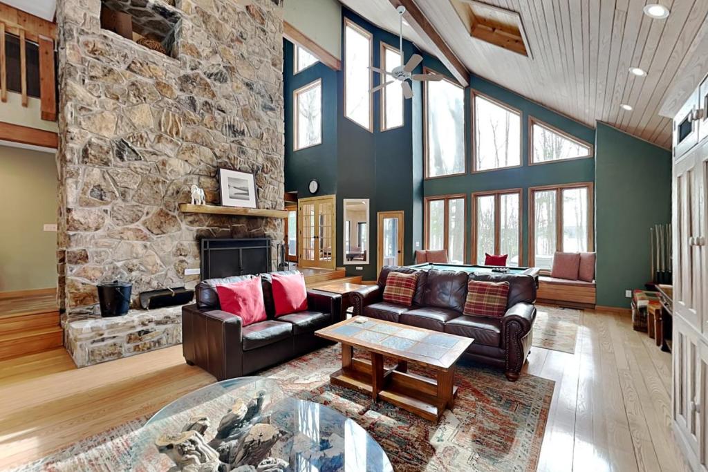 a living room with leather furniture and a stone wall at Shoreline Chateau in Swanton