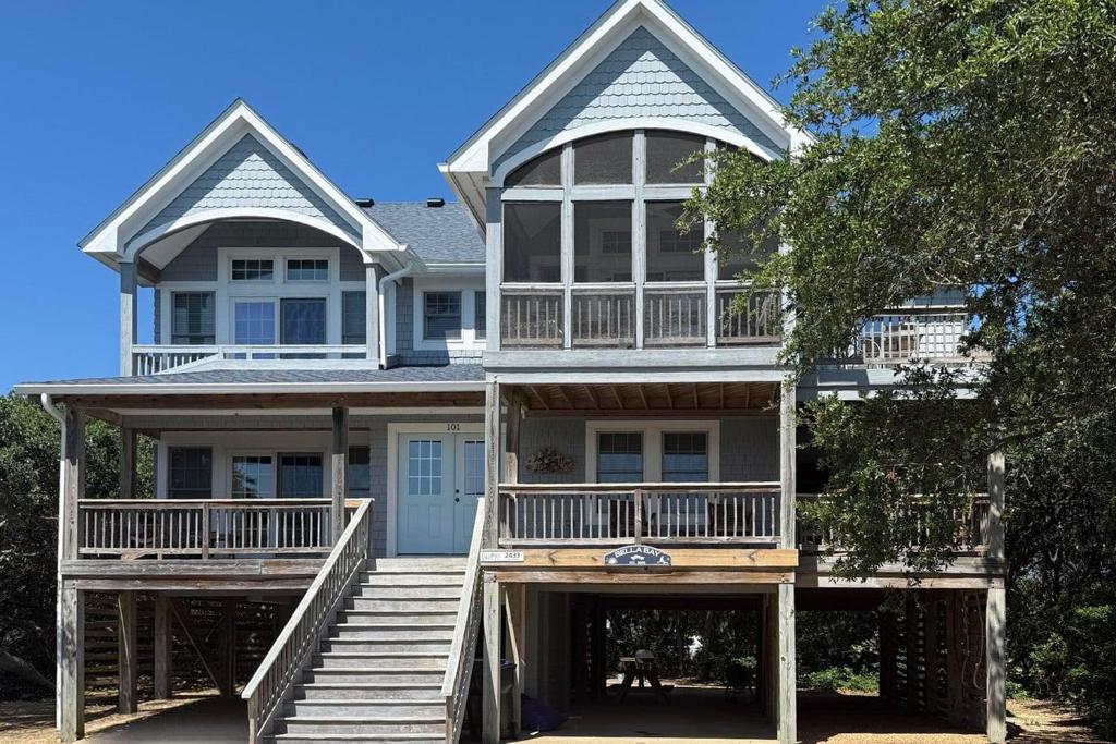 a large house with two stories and a porch at 2433 - Bella Bay in Duck