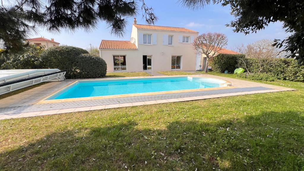 a swimming pool in front of a house at Les Ptis Bregeons in Talmont