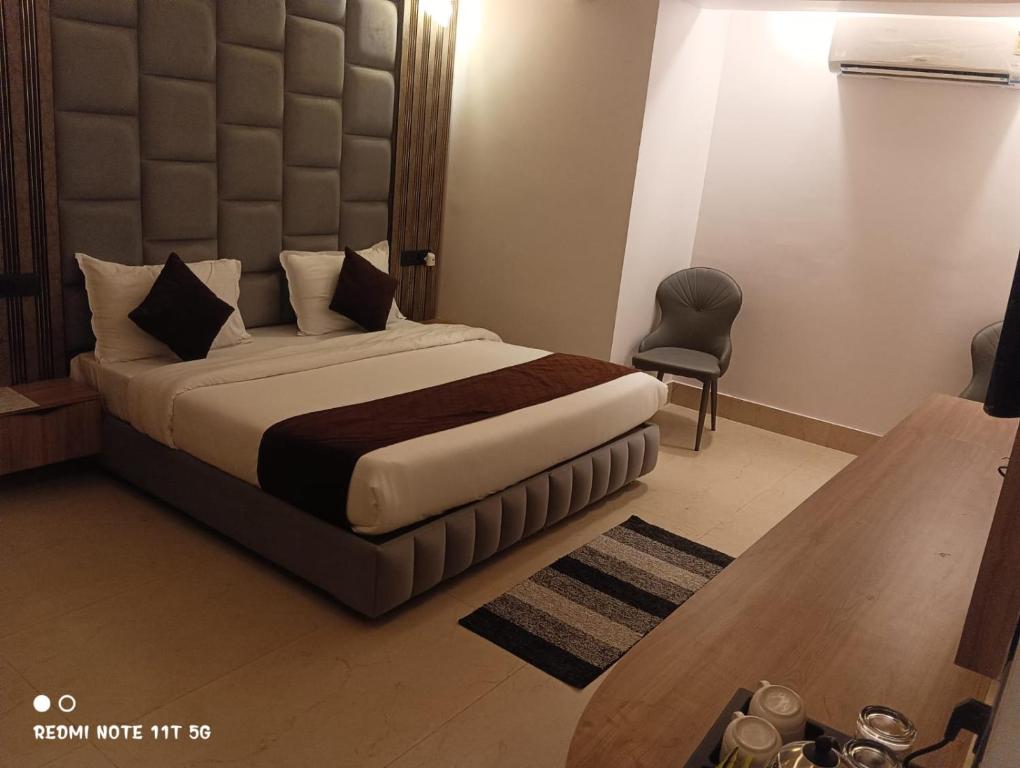 a hotel room with a bed and a chair at Jayati Palace Hotel in Rudraprayāg
