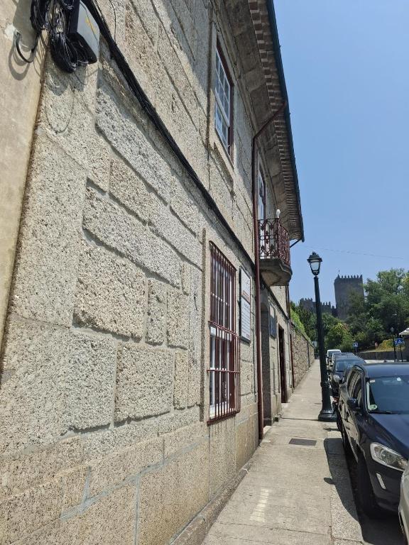 a brick building with a window on a sidewalk at 4-As Andar-Moradia Castelo in Guimarães