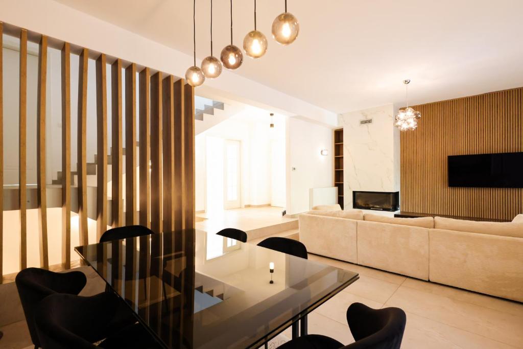 a living room with a couch and a table and chairs at Pool and Spa Retreat Villa in Tirana