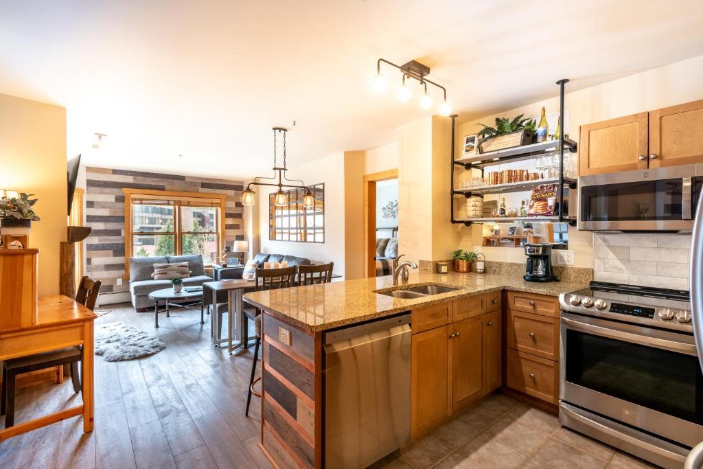 a kitchen with wooden cabinets and a living room at Copper Springs Lodge 332 in Copper Mountain