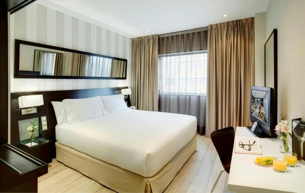 a hotel room with a bed and a television at Sercotel Madrid Aeropuerto in Madrid