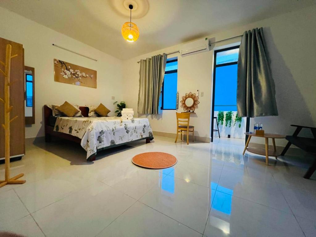 a large living room with a bed and large windows at KyNa House in Rạch Giá