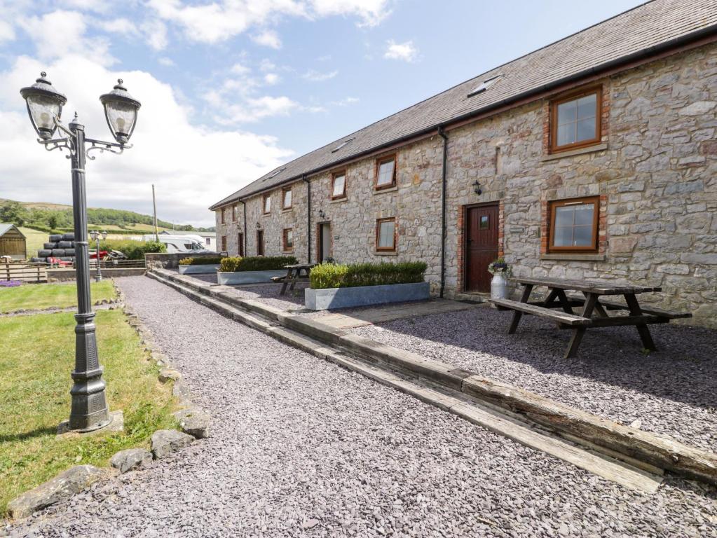 a stone building with a picnic table and a street light at Stabal-y-Gwedd in Llanddulas