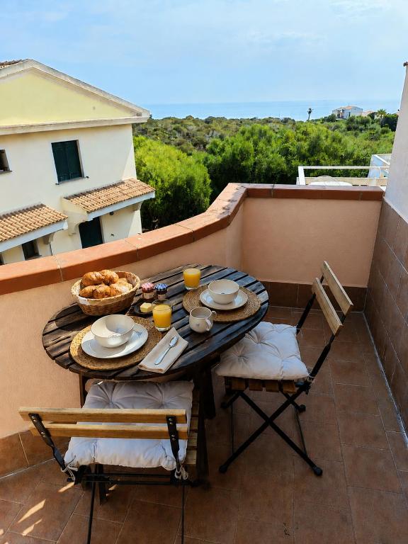 a table and chairs sitting on a balcony with a table and chairs at Il Mascone in Stintino