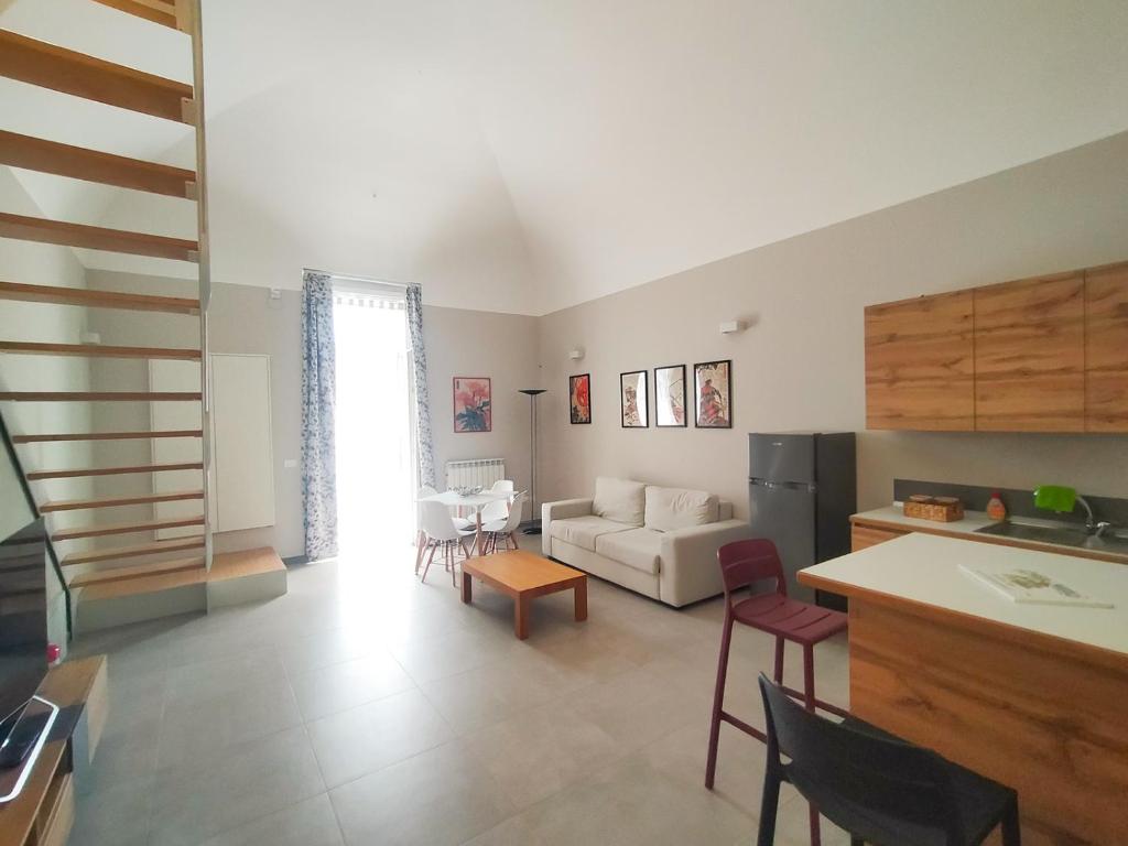 a living room with a white couch and a kitchen at Casa Mario in San Severo