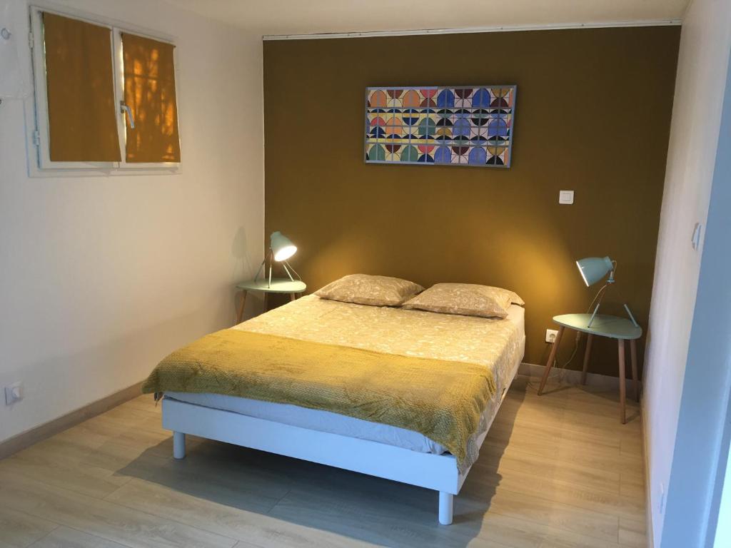 a bedroom with a bed and two lamps in it at Au Petit Paradis in Balan
