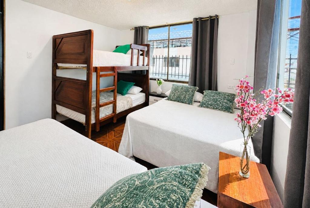 a room with two beds and a bunk bed at Villa Aurora 3 Bedroom 2 Baths in Baños