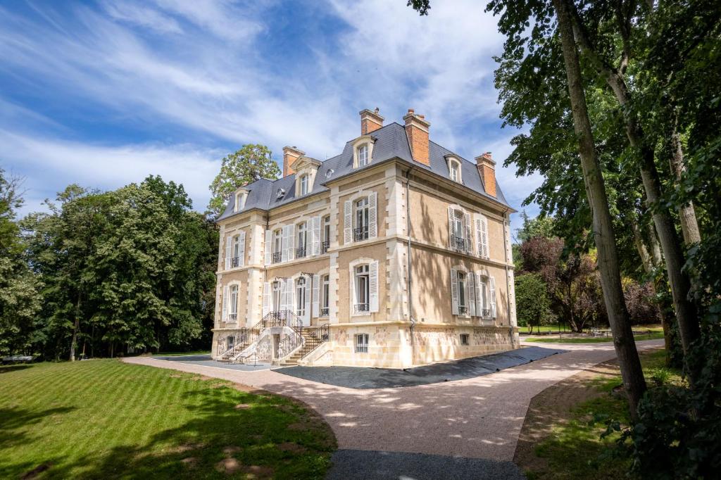 an old stone house with trees in front of it at Domaine de La Bourse in Vérigny