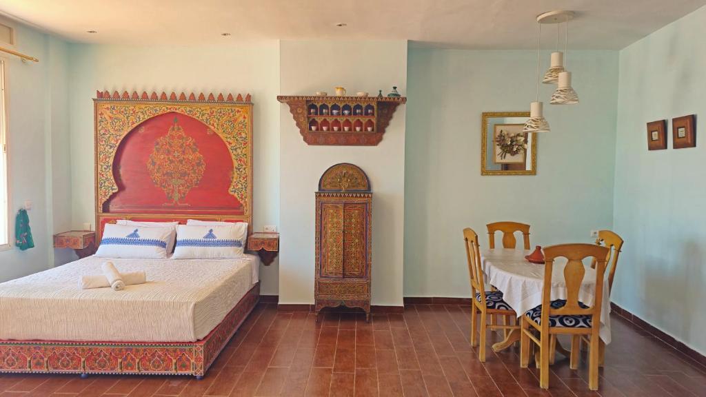 a bedroom with a bed and a table and chairs at Indigo House in Chefchaouen