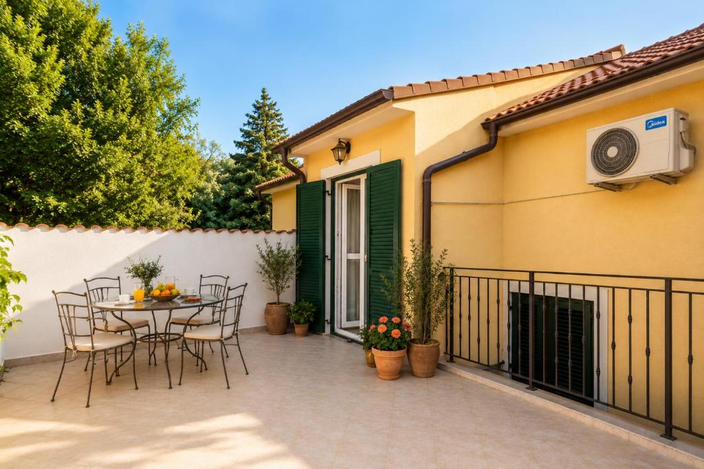 a patio with a table and chairs and a fence at Studio Apartman Blue Sky in Senj