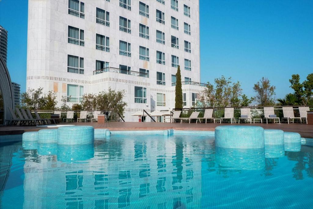 a swimming pool in front of a building at Sercotel Sorolla Palace in Valencia