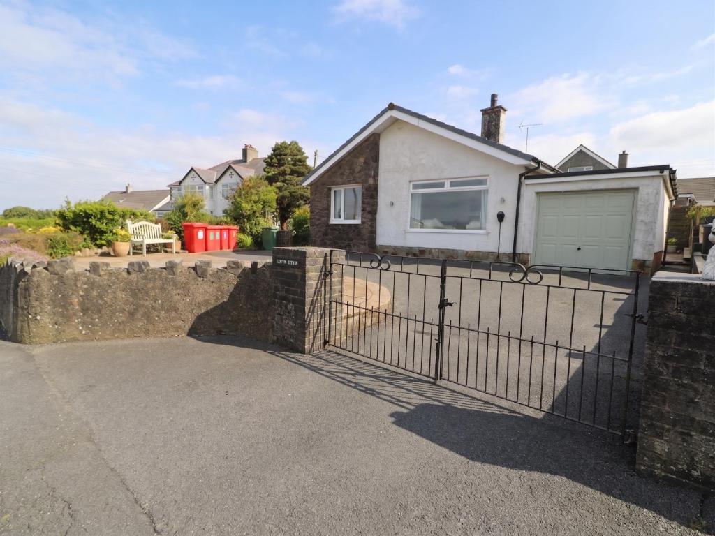 a house with a gate and a driveway at Llwyn Eithin in Benllech