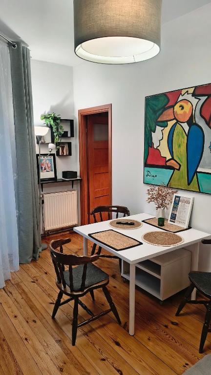 a room with a table and chairs and a painting at Chrobry Square - Art Apartament in Gorzów Wielkopolski