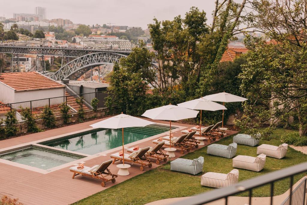 a pool with chairs and umbrellas on a balcony at LENSCAPE Coterie in Porto