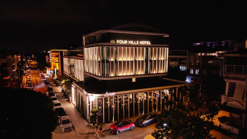a building with cars parked on a street at night at Four Hills Hotel in Antalya