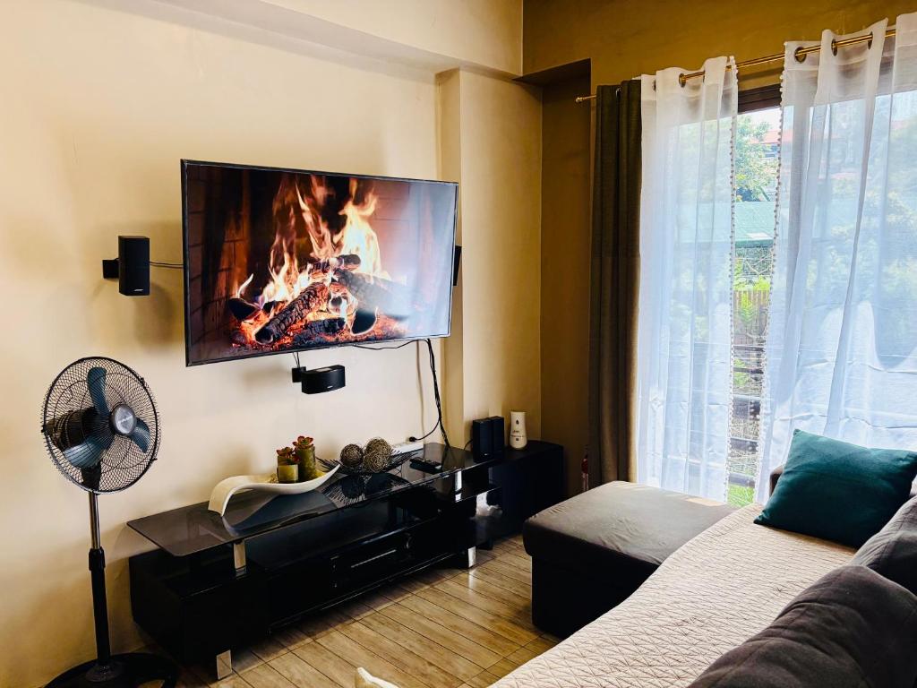 a living room with a fire on the wall at Haku Haven in Baguio