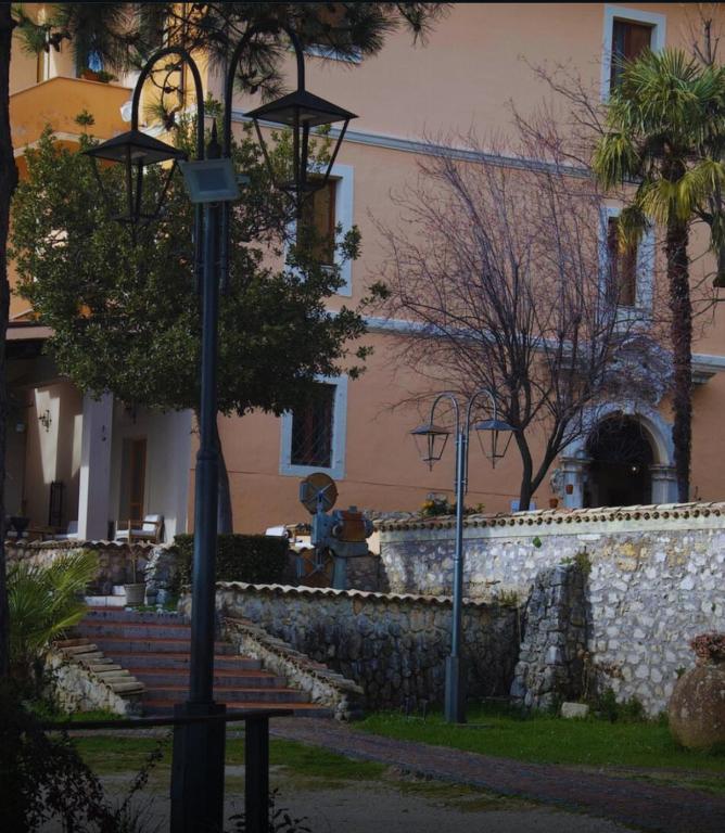 a street light with a bench in front of a building at VillaGrancassa Hotel Relais in San Donato Val di Comino