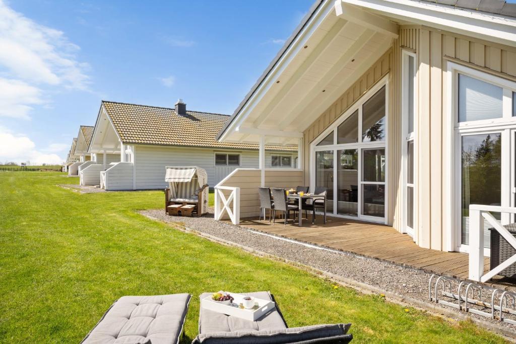 a house with a deck with a table and chairs at Luxuswellnesshaus Ostwind in Bliesdorf