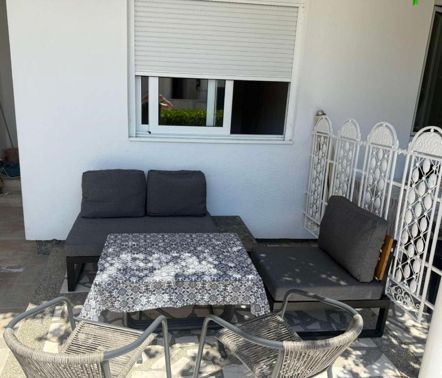 a patio with a couch and a table and chairs at Apartman sa dve spavace sobe, prizemlje, Popović in Petrovac na Moru
