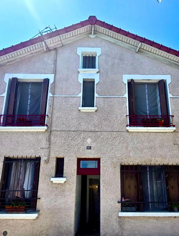 a building with four windows and a door at paris kiffe in Villejuif