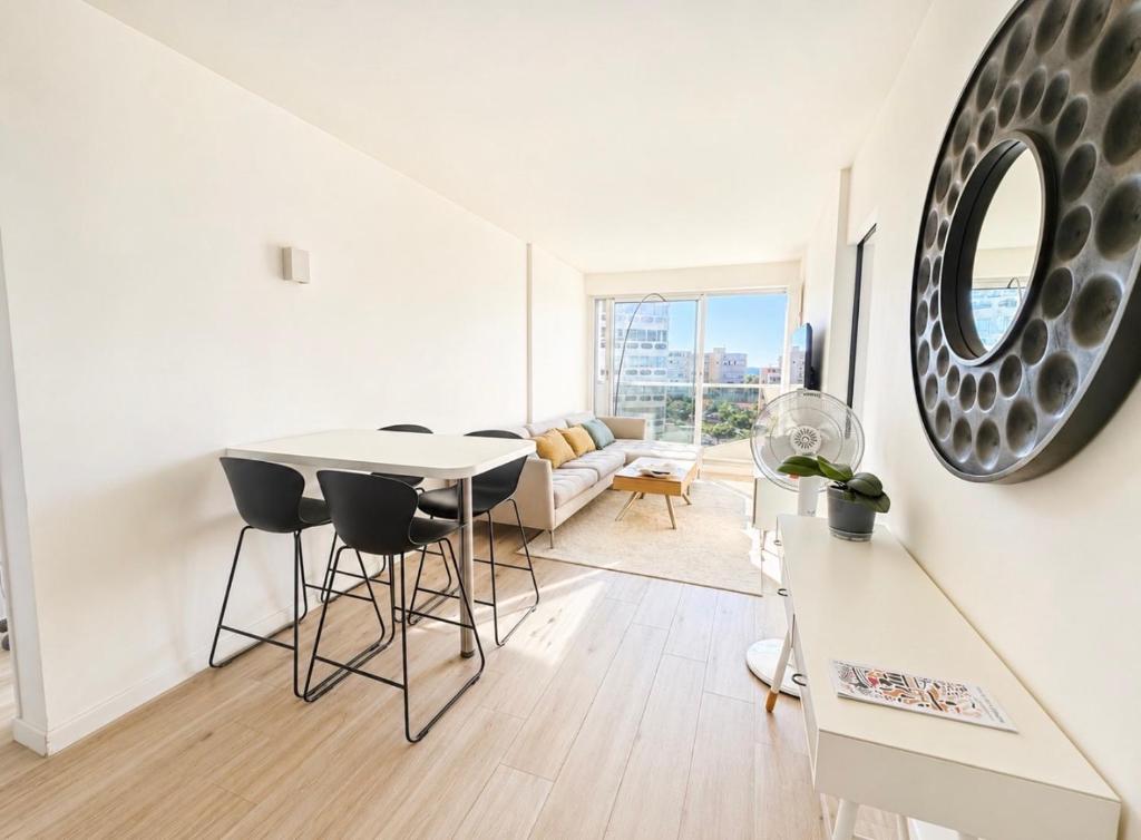 a white living room with a table and chairs at ideal in Carnon-Plage