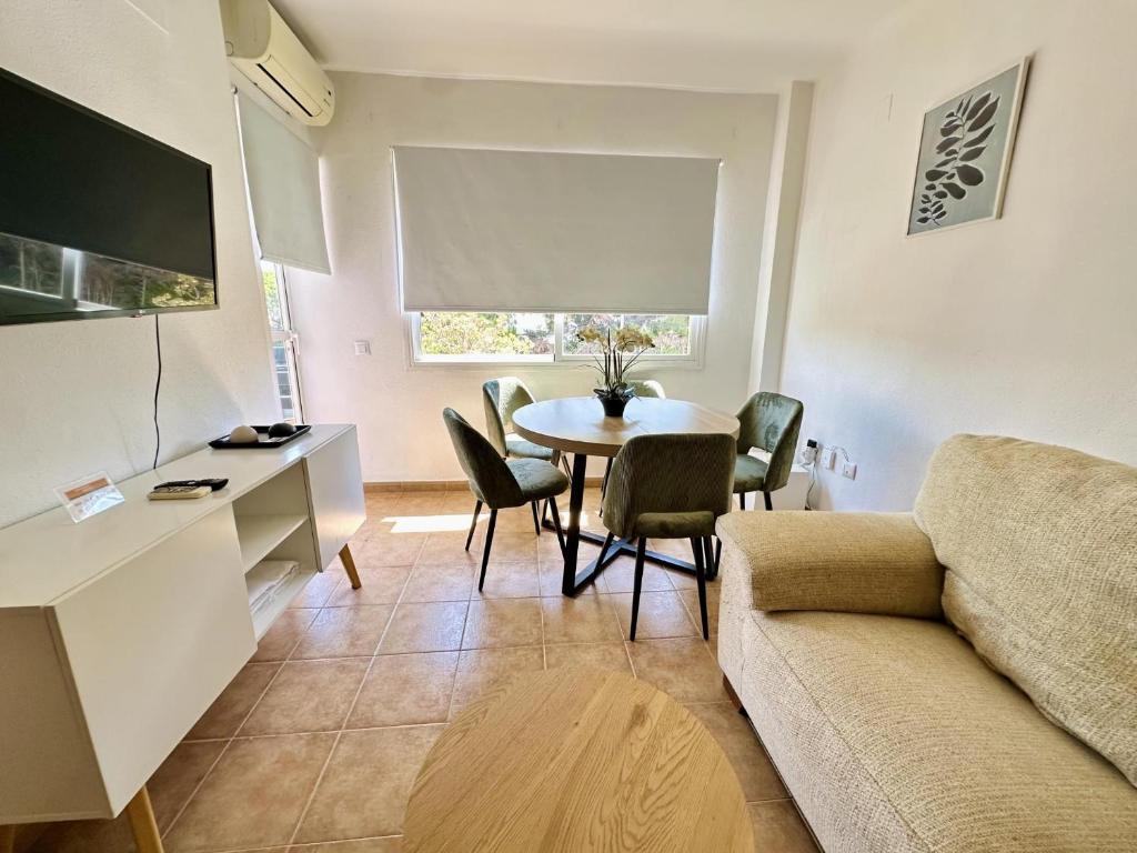 a living room with a table and a couch at Los Pescadores Playa Sol in Novo Sancti Petri