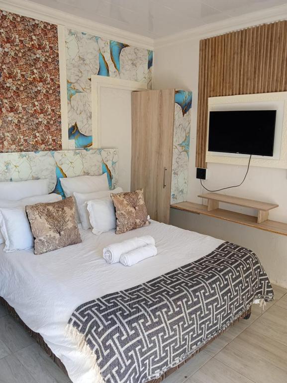 a bedroom with a large white bed with towels on it at MRH Self Check- In Express Homestay in Modimolle