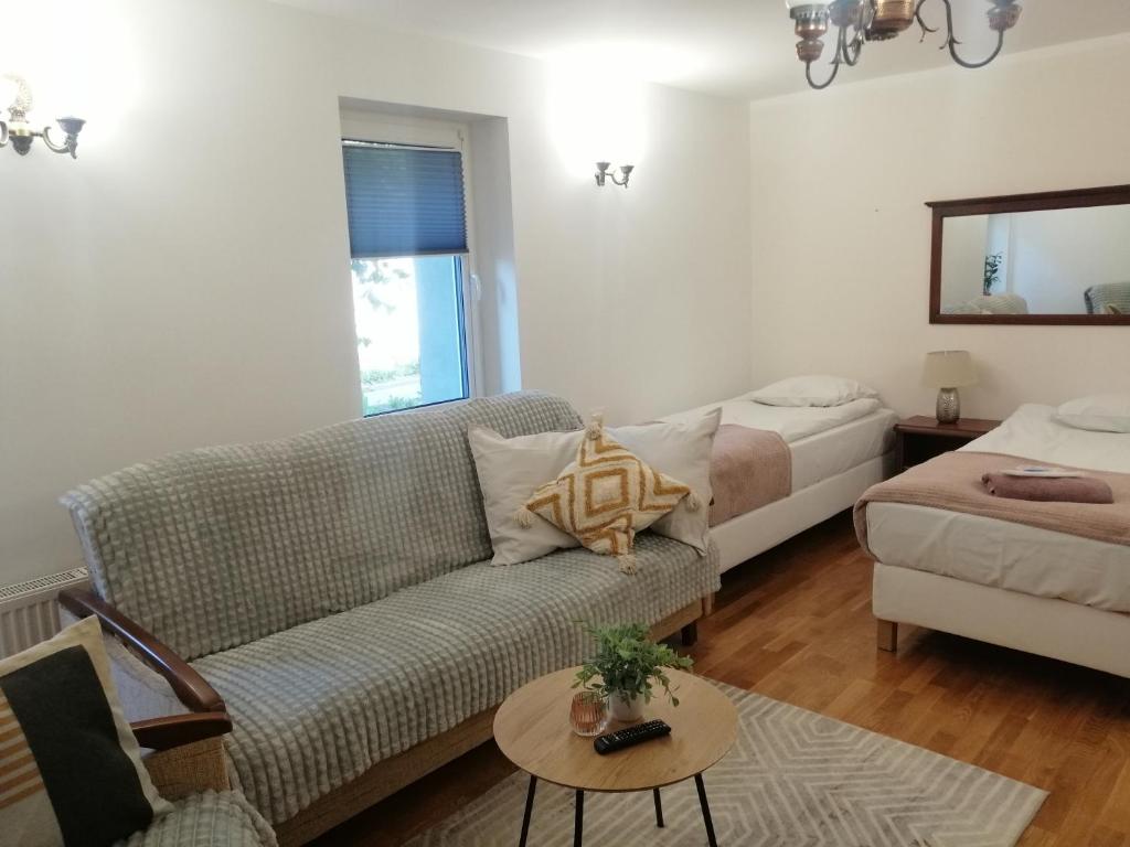 a living room with a couch and a bed at Sky&Lake Apartments Gdańsk in Gdańsk