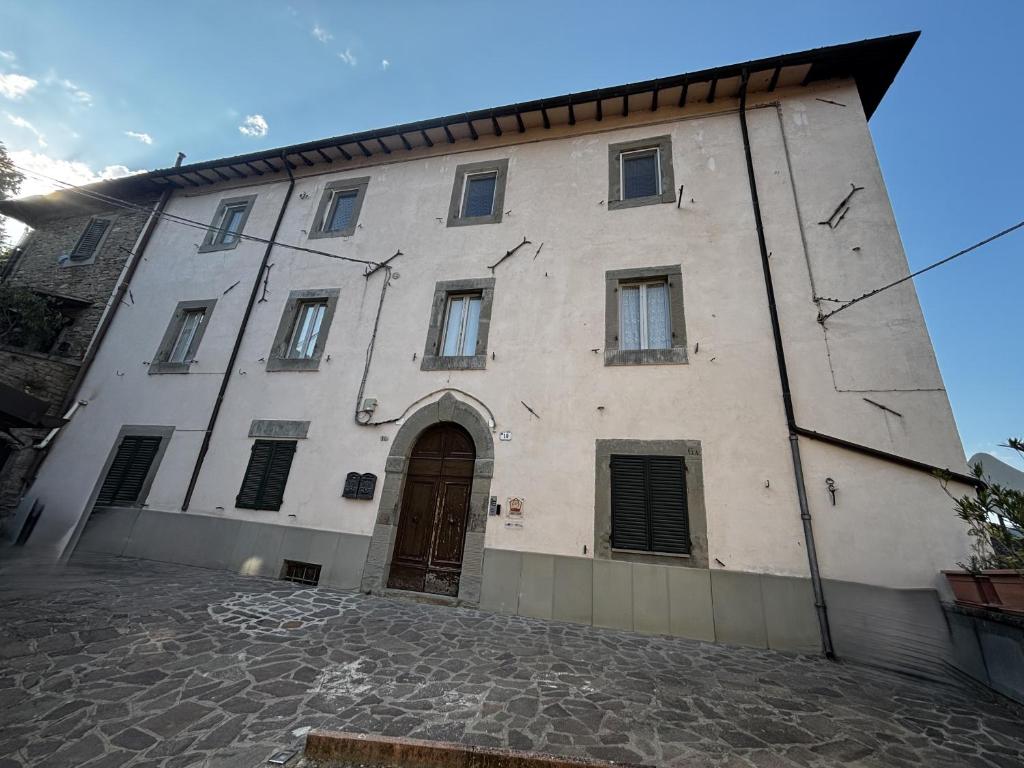 a large white building with a door on a street at Casa Guidi in Santa Sofia