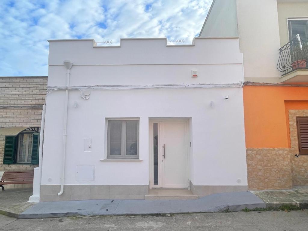 a white building with a door on the side at La Volta di Chiara in Roccaforzata