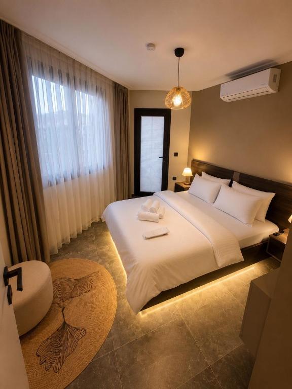 a bedroom with a large white bed and a window at Mirşah Suit in Dalaman