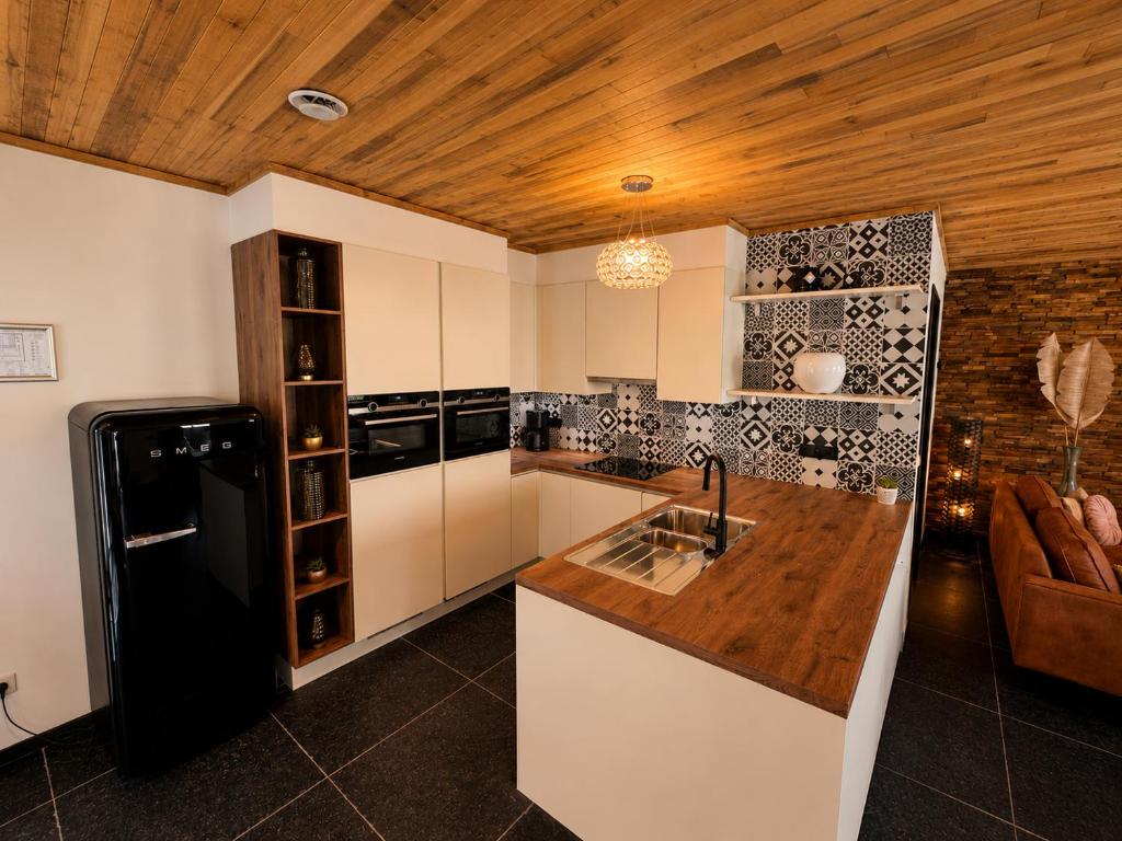 a kitchen with a black refrigerator and a counter at VinOli Holiday Home in Alveringem