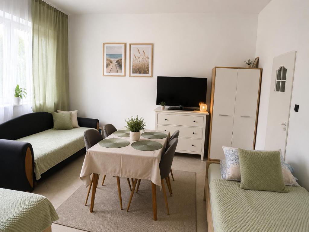 a living room with a table and a couch at Pomarańczowy Domek in Junoszyno