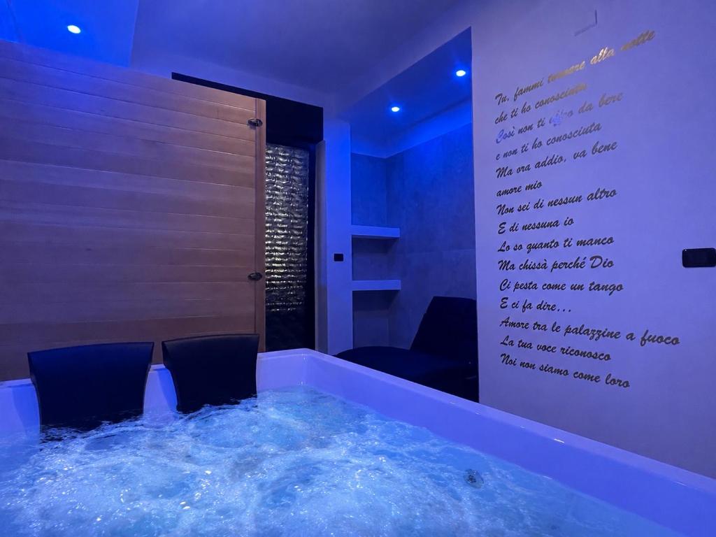 a room with a tub with a writing on the wall at B&B CORSO ROMA Room Suite & Spa in Apricena