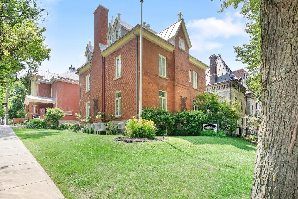 a large red brick building with a grass yard at Manoir de la Tour - Par Aneyro in Quebec City