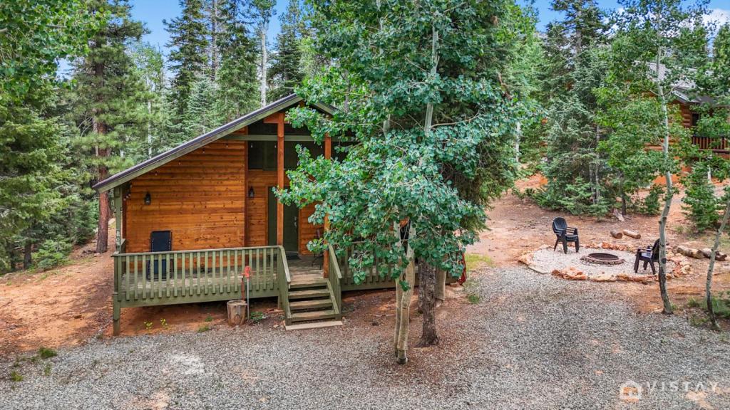 a log cabin in the middle of a forest at Lovely Log Cabin With Fire Pit! in Duck Creek Village