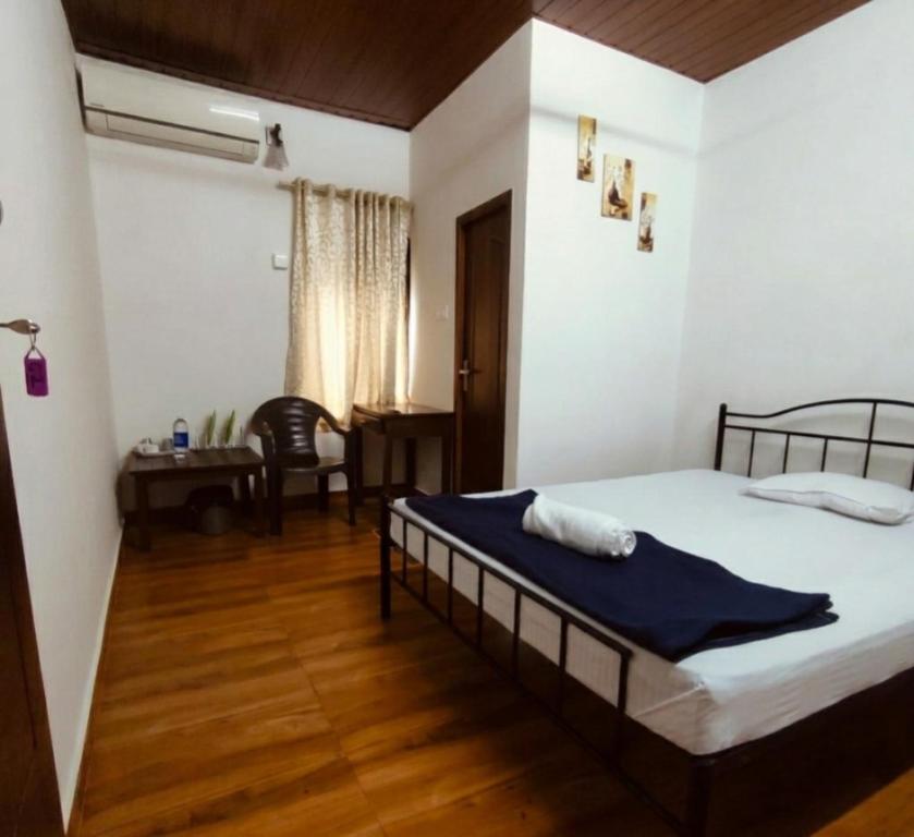 a bedroom with a bed and a table and a desk at Ebenezer Stay in Trivandrum