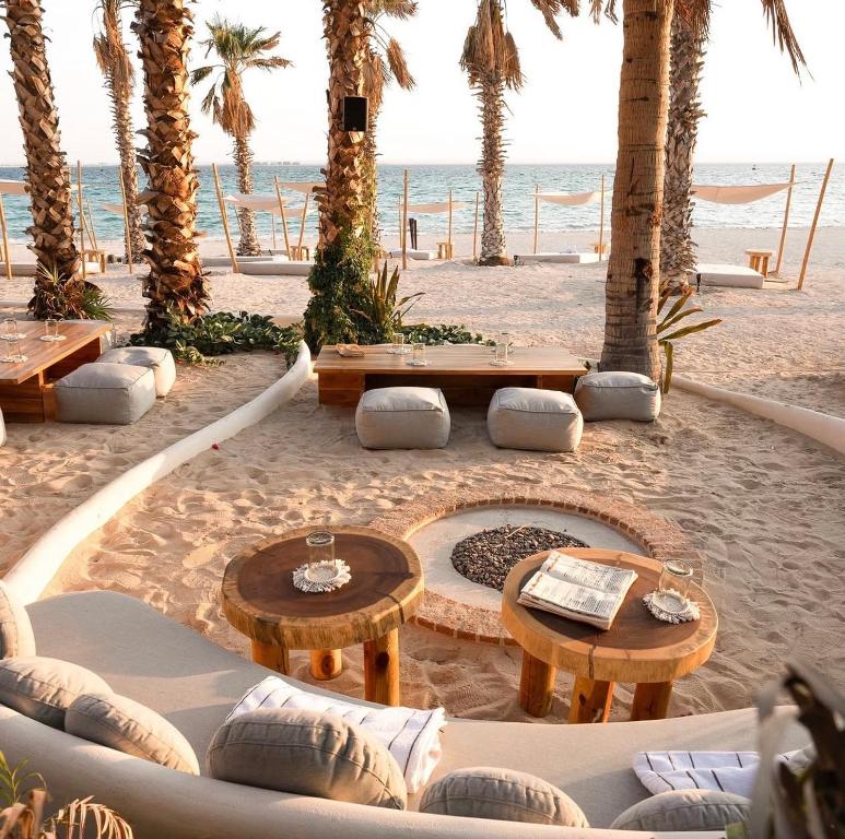 a beach with tables and benches and palm trees at Condo Cortes La Paz in La Paz