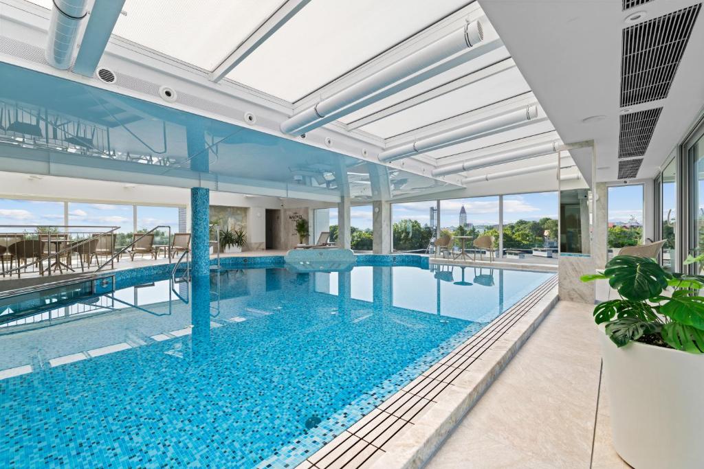 an indoor swimming pool in a house with glass walls at Maloves Resort & Spa in Władysławowo