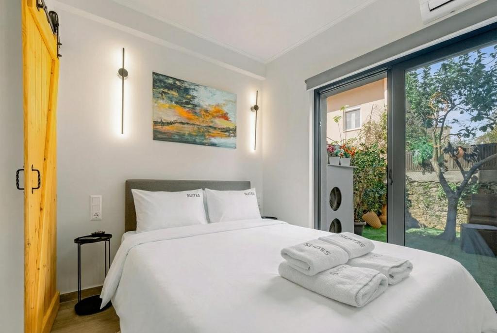 a bedroom with a white bed with two towels on it at InTown Suite in Lefkada
