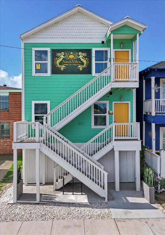 a green house with white stairs on it at Ninas Villas - Brand New Luxury Villas in Galveston