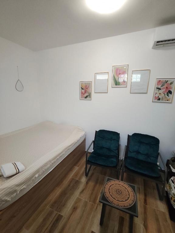 a bedroom with two chairs and a bed and a table at Studio 714 in Škaljari