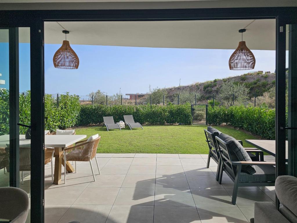 a patio with a table and chairs and a lawn at Higuerón Prestige homes in Fuengirola
