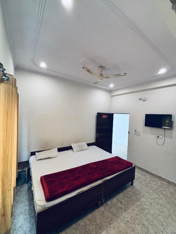 a bedroom with a bed with a red comforter at Barsana Geust House in Khātu
