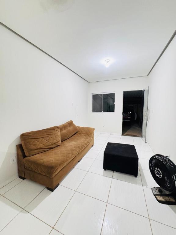 a living room with a brown couch and a black stool at Casa Mobiliada Plus Gurupi in Gurupi